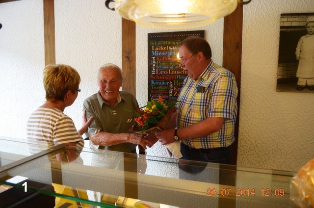 Eheleute Leni und Bernward Hennes überraschen den ältesten und treuesten Kunden, Heinz Steinhanses  mit einem Blumenstrauß, um ihm und seiner Frau Anita den Abschied vom Geschäft Leopolds zu erleichtern.